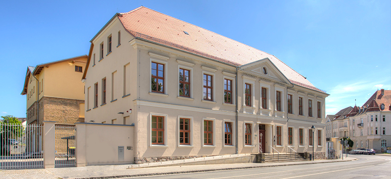 Das Gebäude des Landessozialgericht - helles Gebäude mit Ziegeldach