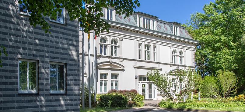 DAs Gerichtsgebäude hinter einer Baumgruppe