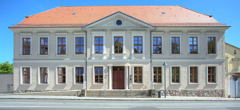 Das Gerichtsgebäude des Amtsgericht Waren in weiß mit rotem Ziegeldach
